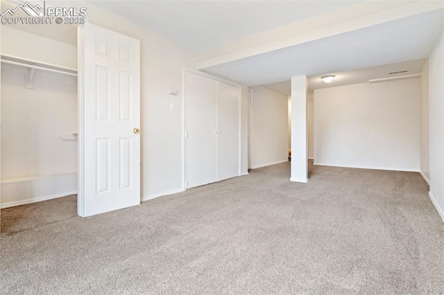 unfurnished bedroom featuring carpet, baseboards, and multiple closets