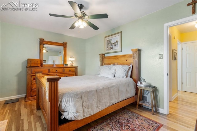 bedroom featuring light wood-style floors, a ceiling fan, and baseboards