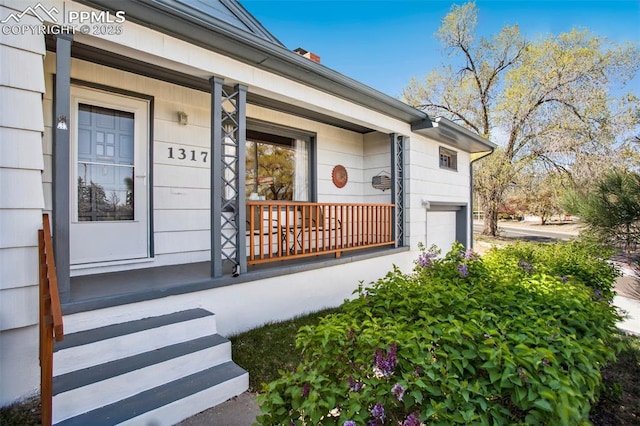 property entrance with an attached garage and covered porch
