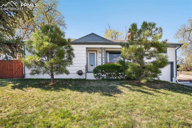 view of front of property with fence, a front yard, and a chimney