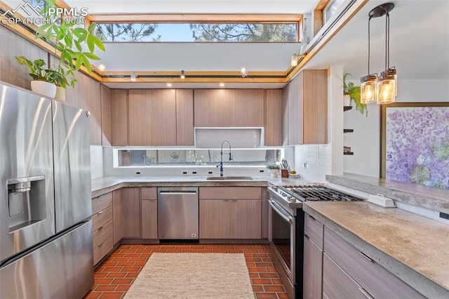 kitchen featuring a sink, decorative backsplash, appliances with stainless steel finishes, and brick floor