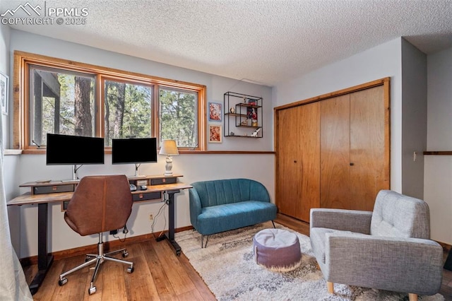 home office featuring a textured ceiling, baseboards, and hardwood / wood-style floors