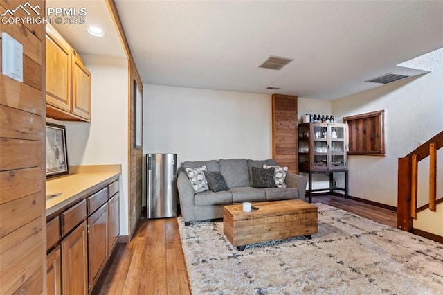 living room featuring baseboards, visible vents, and light wood-style floors