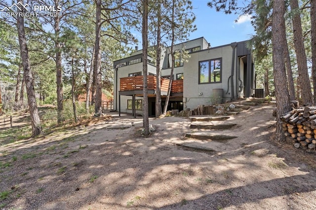 back of house featuring cooling unit and a wooden deck