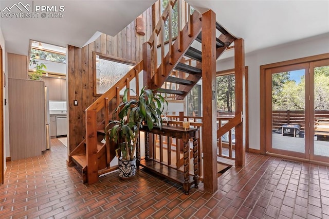 stairs with brick floor, wood walls, and a wealth of natural light