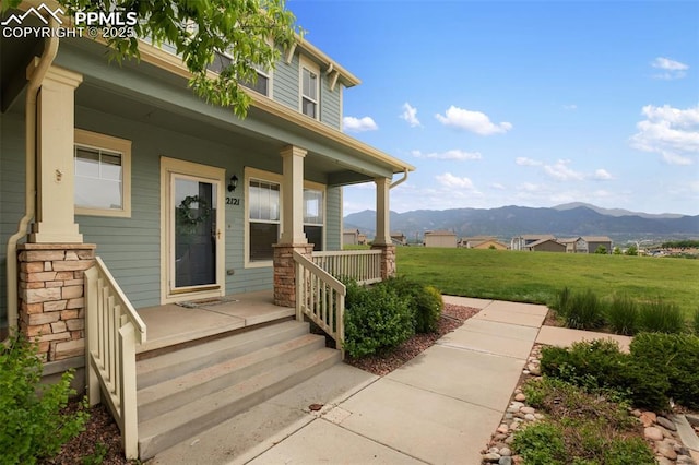 2121 Gilpin Ave, Colorado Springs, CO 80910 - view of exterior entry with a porch, a mountain view, and a yard