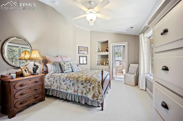 bedroom featuring light colored carpet, connected bathroom, lofted ceiling, and multiple windows