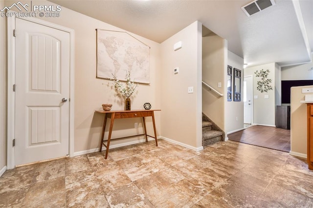 entryway featuring stairs, baseboards, and visible vents