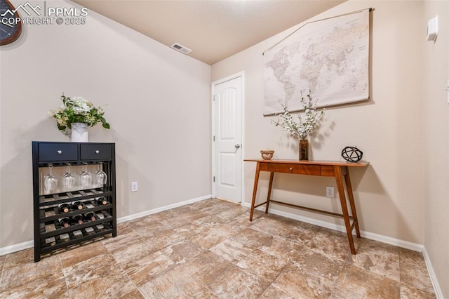 entrance foyer featuring visible vents, baseboards, and stone finish floor
