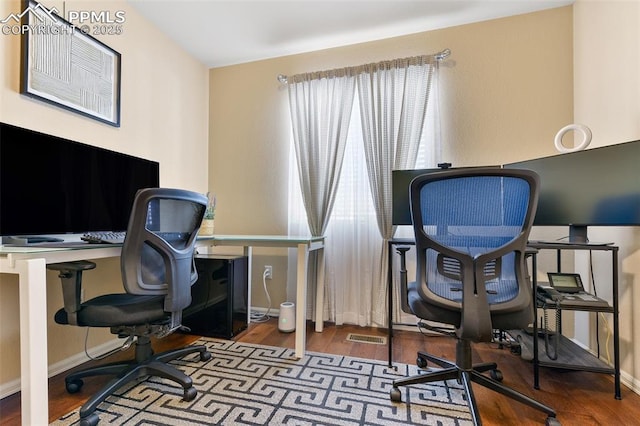 home office with baseboards, wood finished floors, and visible vents