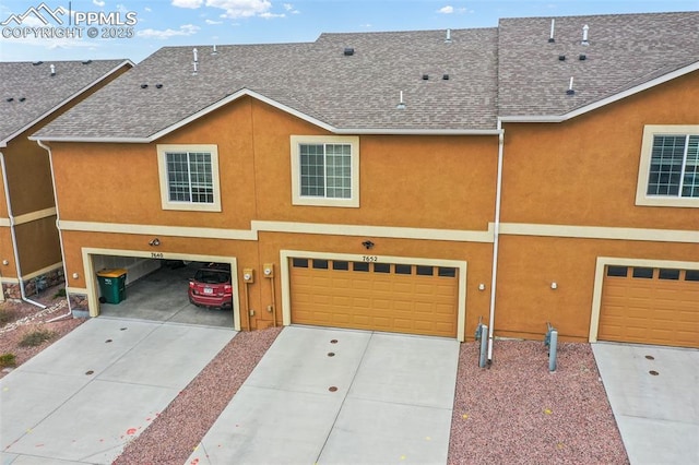 exterior space featuring an attached garage, a shingled roof, concrete driveway, and stucco siding