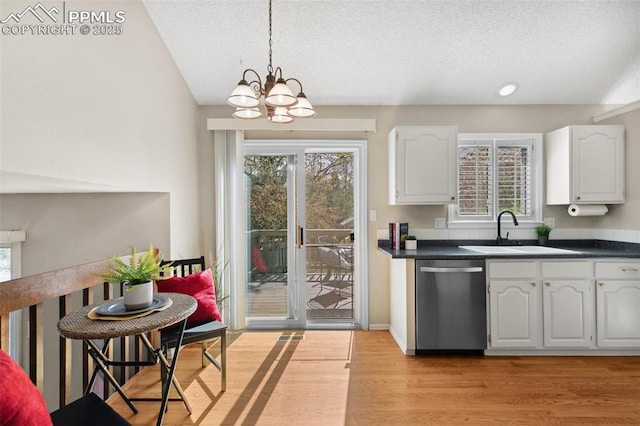 kitchen with a sink, dark countertops, a textured ceiling, and dishwasher