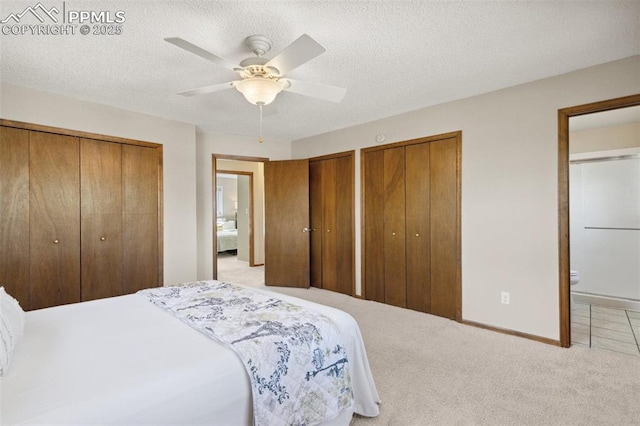 bedroom with connected bathroom, ceiling fan, carpet floors, multiple closets, and baseboards