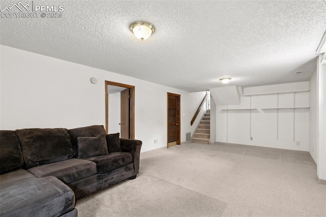 living room featuring a textured ceiling, visible vents, light colored carpet, baseboards, and stairs