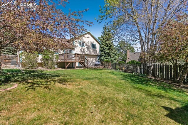 view of yard featuring stairs, a fenced backyard, and a deck