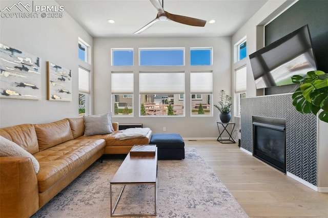 10323 Elevated Ln, Colorado Springs, CO 80924 - living area featuring ceiling fan, a tile fireplace, plenty of natural light, and wood finished floors