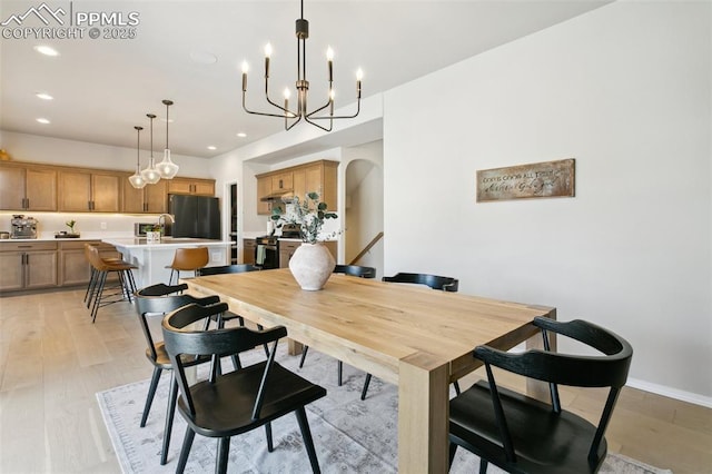10323 Elevated Ln, Colorado Springs, CO 80924 - dining area featuring an inviting chandelier, light wood-style flooring, arched walkways, and recessed lighting
