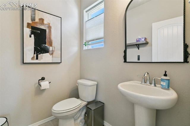 10323 Elevated Ln, Colorado Springs, CO 80924 - half bathroom featuring baseboards, toilet, and a sink