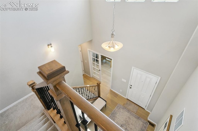 10323 Elevated Ln, Colorado Springs, CO 80924 - stairway featuring a towering ceiling, baseboards, visible vents, and wood finished floors