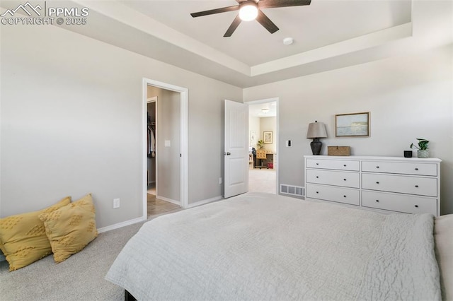 10323 Elevated Ln, Colorado Springs, CO 80924 - bedroom featuring a ceiling fan, a tray ceiling, visible vents, baseboards, and light carpet
