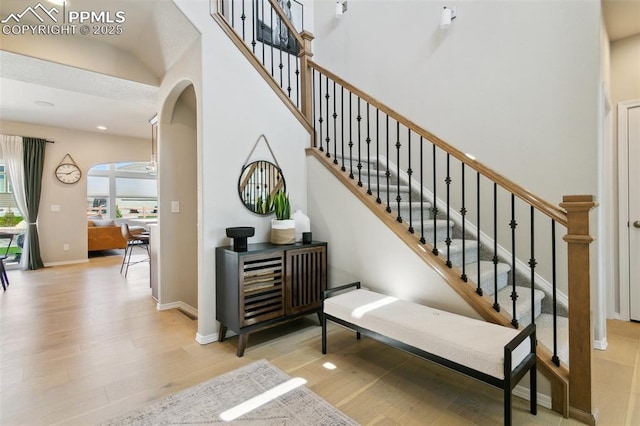 10323 Elevated Ln, Colorado Springs, CO 80924 - stairway with wood finished floors, baseboards, arched walkways, and recessed lighting