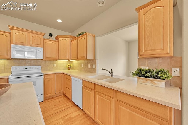 kitchen featuring white appliances, light brown cabinetry, a sink, and light wood-style floors