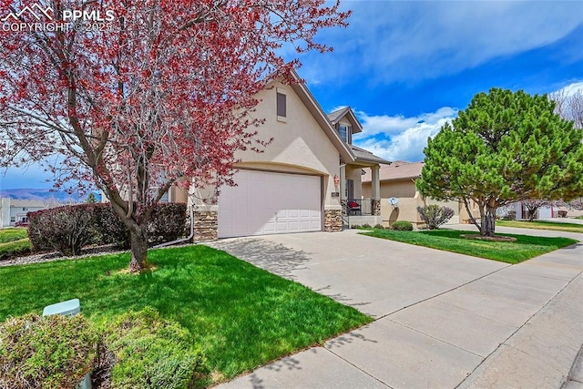 view of front of house featuring a front yard, driveway, stone siding, and stucco siding