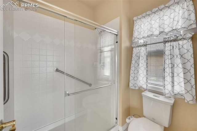 full bath with a shower with shower door and toilet