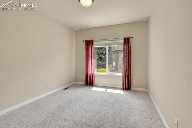 carpeted spare room with visible vents and baseboards