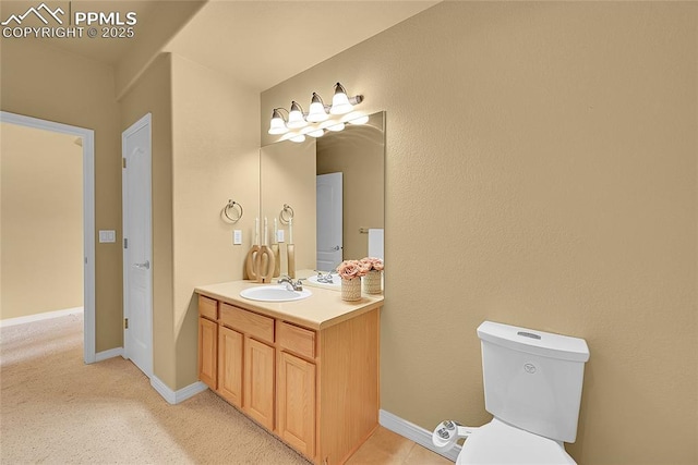 bathroom with vanity, baseboards, and toilet