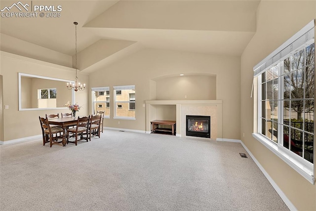 carpeted dining space featuring visible vents, baseboards, a glass covered fireplace, and lofted ceiling
