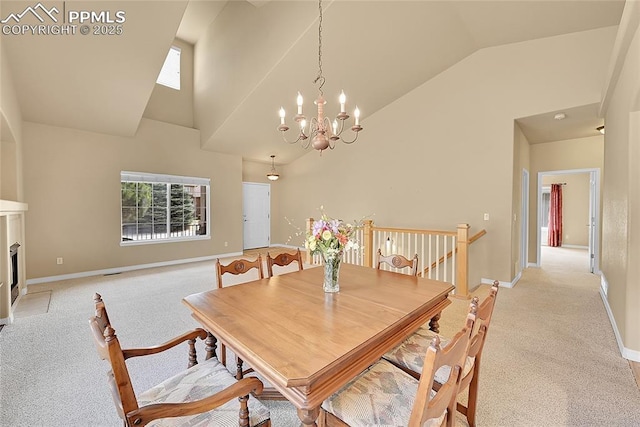 dining space featuring high vaulted ceiling, plenty of natural light, a chandelier, and light colored carpet