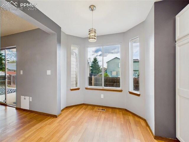 3130 Haystack Dr, Colorado Springs, CO 80922 - unfurnished dining area with visible vents, light wood finished floors, and baseboards