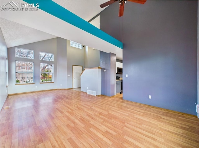 3130 Haystack Dr, Colorado Springs, CO 80922 - unfurnished living room featuring visible vents, baseboards, ceiling fan, high vaulted ceiling, and light wood finished floors