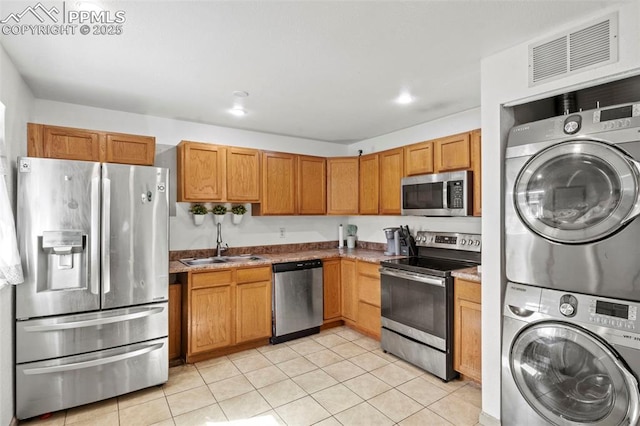 2246 Bison Dr, Colorado Springs, CO 80911 - kitchen with visible vents, appliances with stainless steel finishes, light tile patterned floors, a sink, and stacked washer and clothes dryer