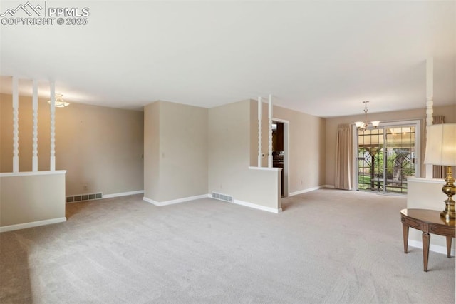 unfurnished living room featuring an inviting chandelier, baseboards, carpet flooring, and visible vents