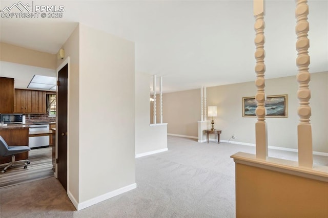 hallway with baseboards and light carpet