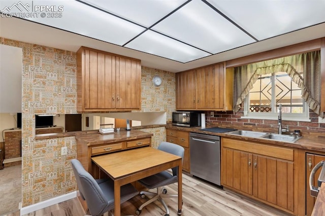 kitchen with stainless steel dishwasher, black microwave, brown cabinets, a sink, and light wood-style flooring
