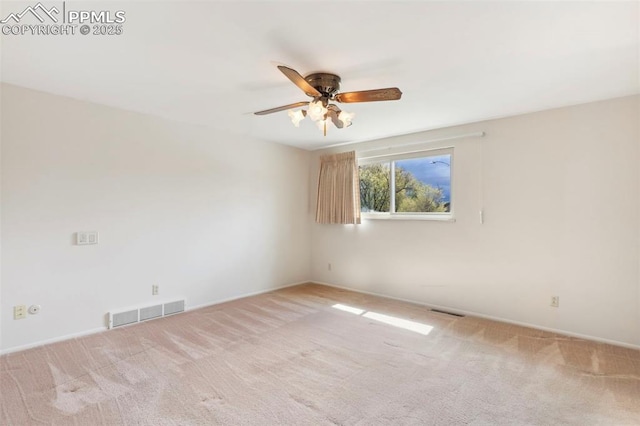 carpeted empty room featuring visible vents, baseboards, and ceiling fan
