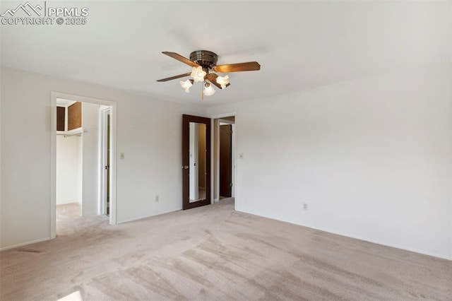 spare room featuring a ceiling fan and light carpet