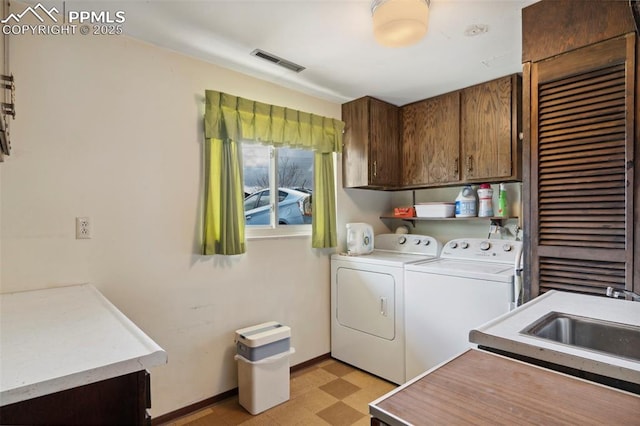 laundry room with visible vents, washer and dryer, baseboards, light floors, and cabinet space