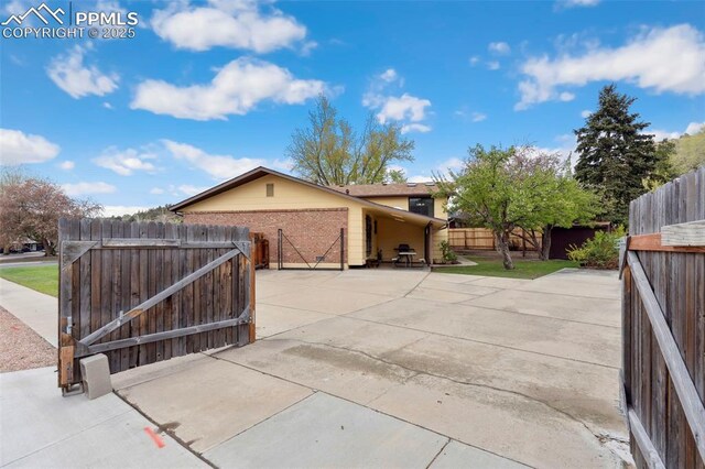 view of gate featuring a fenced backyard and a patio area
