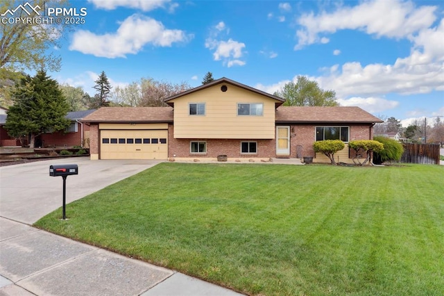 split level home featuring brick siding, a garage, driveway, and a front yard