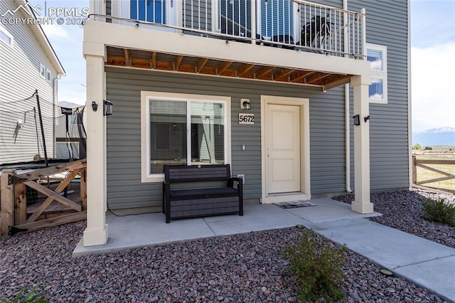 doorway to property with a balcony and fence