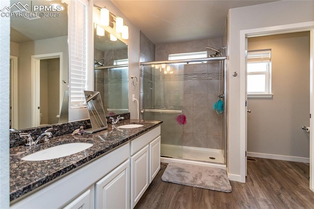 full bath with wood finished floors, a shower stall, and a sink