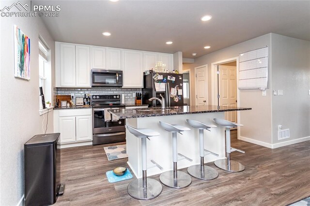 kitchen featuring a sink, dark wood-type flooring, visible vents, white cabinetry, and appliances with stainless steel finishes