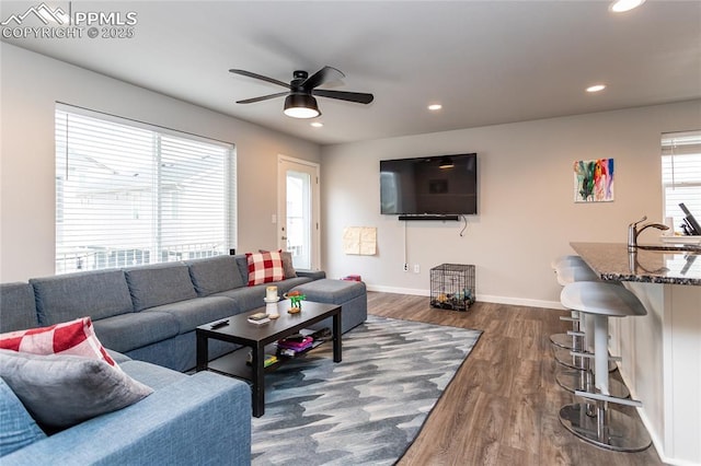 living area with baseboards, wood finished floors, a ceiling fan, and recessed lighting