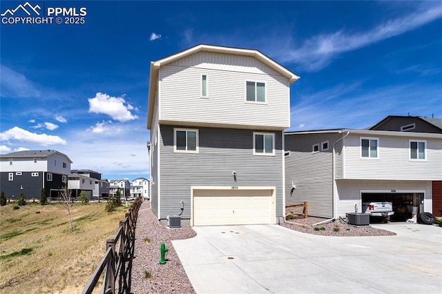 rear view of house featuring fence, an attached garage, and driveway