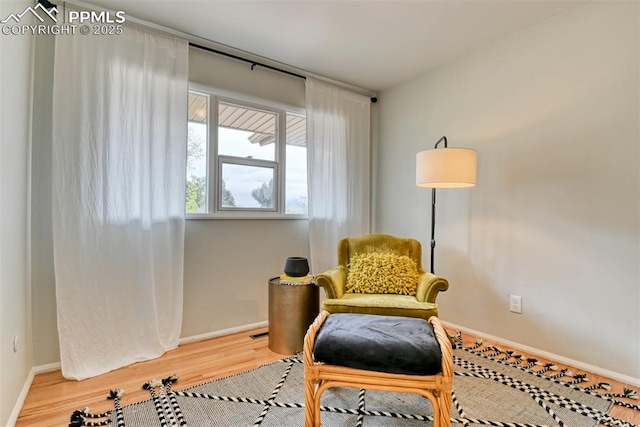living area featuring baseboards, visible vents, and wood finished floors