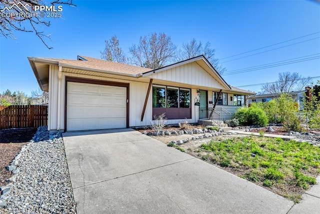 ranch-style home with a garage, fence, a shingled roof, board and batten siding, and concrete driveway